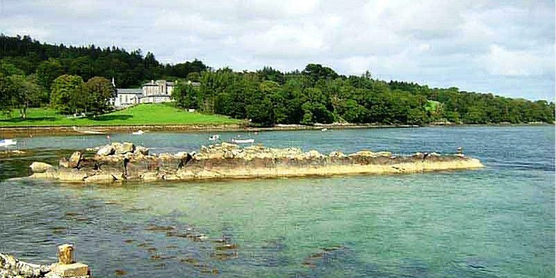 Photograph of a landscape including beach and white building.